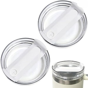 Pode incluir: Duas tampas de plástico transparente com alças brancas e um sinal de mais em cada uma. As tampas são projetadas para caber em um copo ou caneca de viagem.