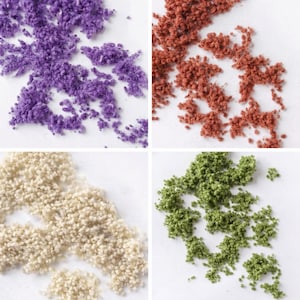 May include: Four sections of colorful craft materials. Top left: purple. Top right: reddish-brown. Bottom left: off-white. Bottom right: green. Each section is composed of small, textured pieces, possibly for model making or decorative purposes.