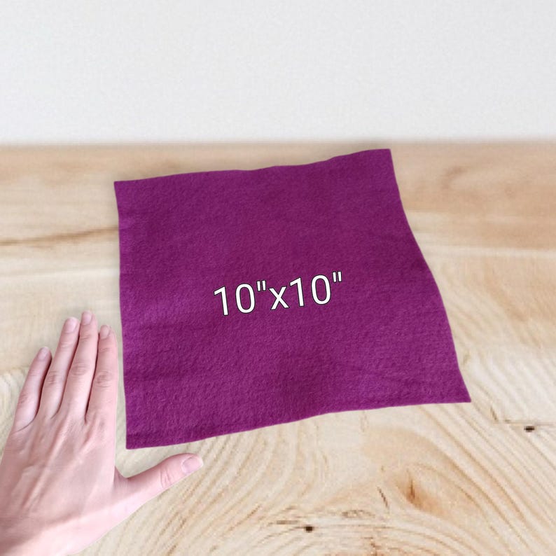 Op de afbeelding: Een vierkant stuk diep magenta vilt met een getextureerd oppervlak. De stof is in het midden bedrukt met de witte tekst 10"x10", wat de afmetingen aangeeft van dit vierkante materiaal voor knutselwerk en diverse projecten.