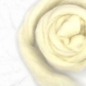 May include: A close-up of a large amount of white wool roving. The wool is soft and fluffy, and it is perfect for felting or spinning.