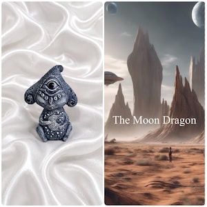 May include: A small, dark grey, textured figurine with a single large eye in the center of its head, holding a crescent moon shape. Beside it, a digital illustration depicts a desert landscape with tall rock formations and the text The Moon Dragon.