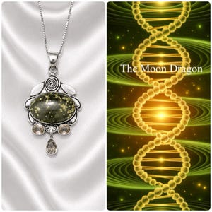 May include: A silver-toned pendant necklace featuring a large, oval, speckled green stone. The pendant has a decorative silver frame with smaller, light brown stones and a teardrop-shaped stone. The background is a white, silky fabric.