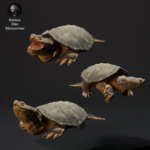 Könnte beinhalten: Drei bemalte Miniatur-Schnapp-Schildkröten in verschiedenen Posen. Die Schildkröten sind braun und grün mit detaillierter Modellierung.