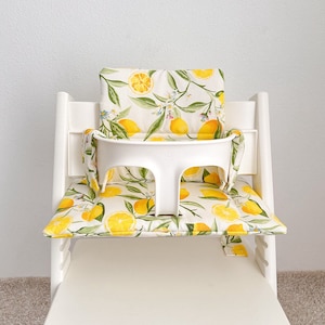 Personalized Tripp Trapp high chair cushion with embroidered child’s name on backrest, stylish custom seat pad in cozy design.