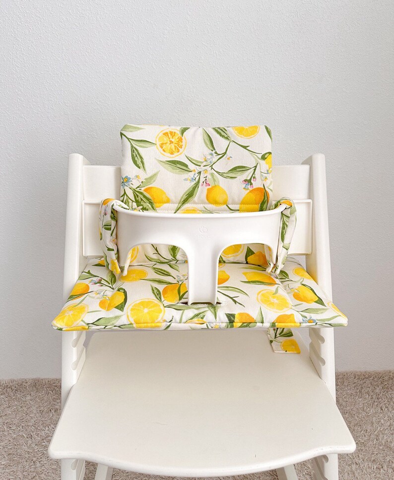 Personalized Tripp Trapp high chair cushion with embroidered child’s name on backrest, stylish custom seat pad in cozy design.