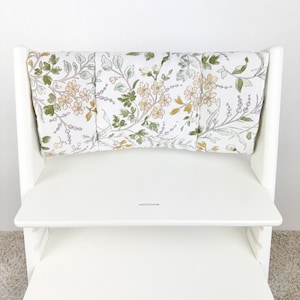 Puede incluir: Silla alta blanca con un coj&iacute;n de estampado floral. El coj&iacute;n est&aacute; hecho de tres piezas separadas que est&aacute;n unidas.
