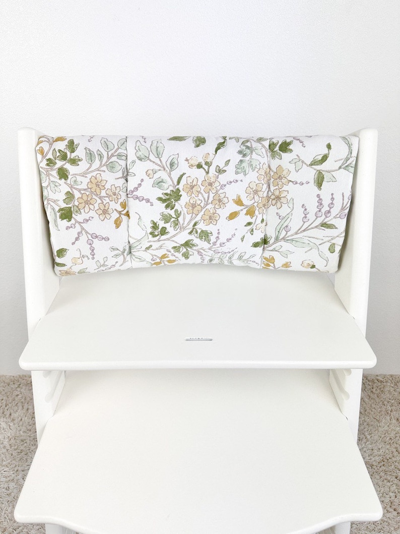 Puede incluir: Silla alta blanca con un coj&iacute;n de estampado floral. El coj&iacute;n est&aacute; hecho de tres piezas separadas que est&aacute;n unidas.