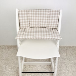Personalized wipeable cushion on Stokke Tripp Trapp chair placed at dining table, stylish highchair accessory blending with modern home decor.