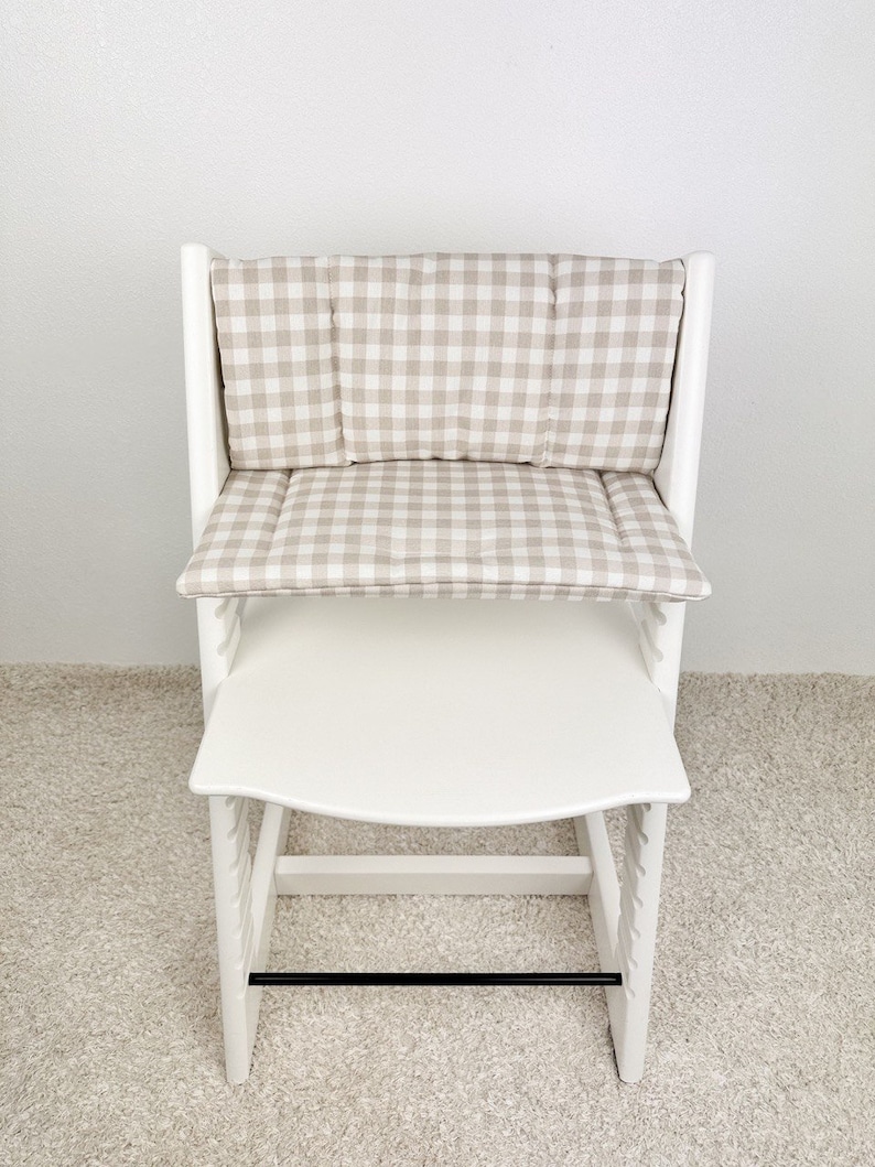 Personalized wipeable cushion on Stokke Tripp Trapp chair placed at dining table, stylish highchair accessory blending with modern home decor.