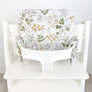 Puede incluir: Silla alta blanca con un coj&iacute;n estampado floral. El coj&iacute;n tiene un dise&ntilde;o floral de color verde claro, amarillo y morado.