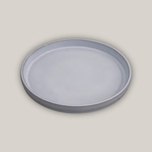 May include: A white ceramic round serving tray with a slightly raised rim.