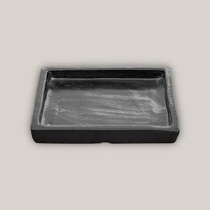 May include: A black square tray made of slate with a smooth, slightly textured surface.
