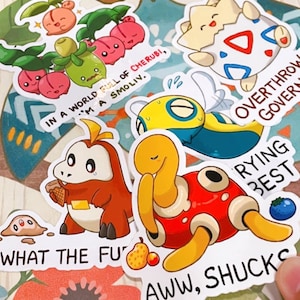 May include: A set of colourful stickers featuring cartoon characters and text. The stickers include a green and pink character with the text "In a world full of Cherubi, I'm a Smoliv.", a yellow and blue character with the text "Overthrow Govern", a red and yellow character with the text "Trying Best", a brown and yellow character with the text "What the Fu", and a red and yellow character with the text "Aww, Shucks".