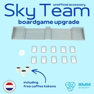 Op de afbeelding: Een grijze 3D-geprinte bordspel-organizer voor Sky Team met een approach en altitude track, tien rechthoekige frame-tokens, één kleine vierkante token en drie witte koffiekop-tokens met zwarte binnenkant, gelabeld als een onofficieel accessoire.