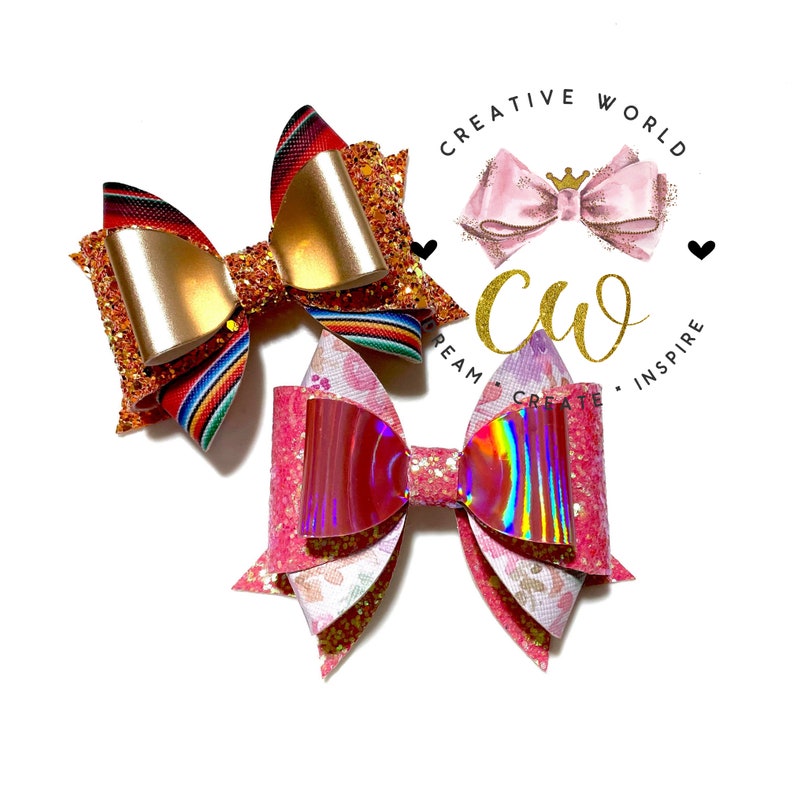 May include: Two handmade hair bows. The first bow is red, orange, and gold with a striped pattern. The second bow is pink and white with a floral pattern and iridescent accents.  The bows are on a white background with the text "Creative World" and "Dream Create Inspire" in black.