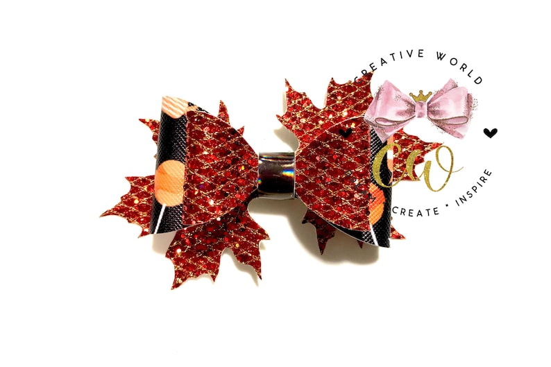 May include: A red and black glitter maple leaf hair bow with gold accents. The bow is attached to a silver alligator clip.