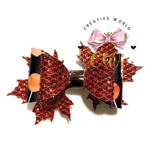 May include: Red and black glitter maple leaf hair bow with a black and orange polka dot pattern. The bow is attached to a silver alligator clip.