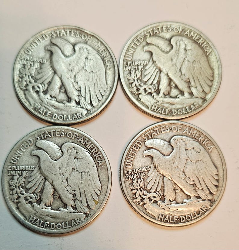 May include: Four silver United States half dollar coins with the image of an eagle on the front. The coins are from the 1900s.