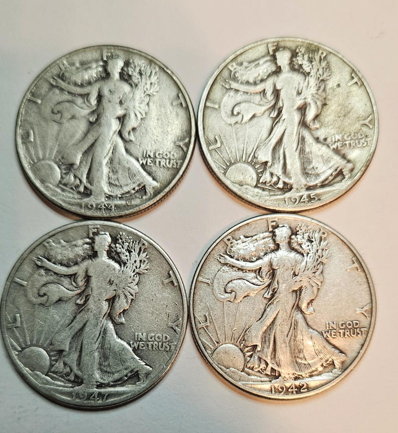 May include: Four silver Walking Liberty half dollar coins from 1942, 1944, 1945, and 1947. Each coin features the image of Liberty walking with a torch and an olive branch, with the inscription "In God We Trust" and the year of minting.