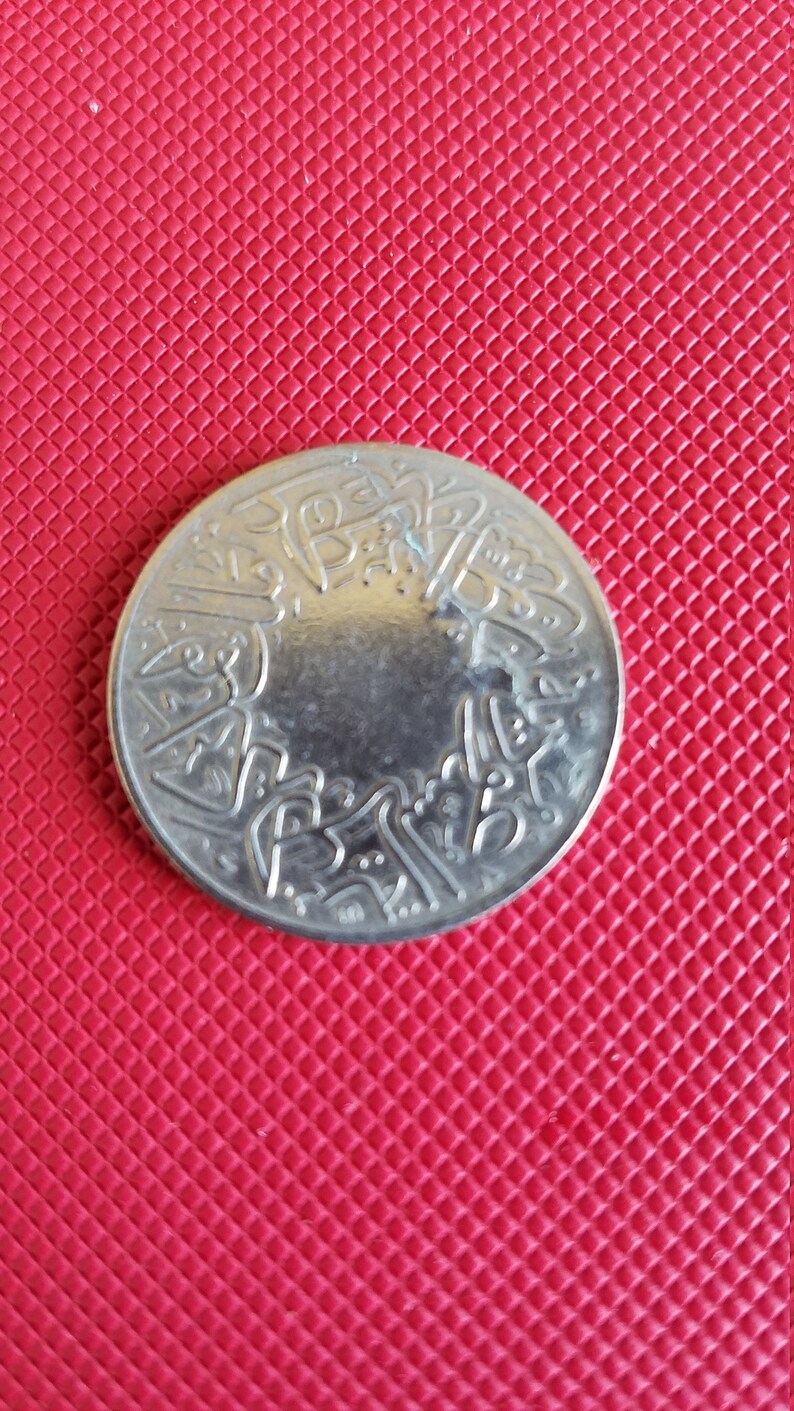 Peut inclure: Une pi&egrave;ce d'argent avec des caract&egrave;res arabes sur le bord.