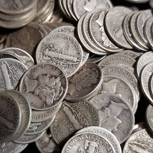 May include: A close-up of a pile of silver coins, mostly dimes, with the words "One Dime" and "United States of America" visible on some of the coins.