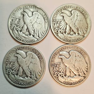 May include: Four silver United States half dollar coins with the image of a bald eagle on the front. The coins are from the 1900s and have the words "United States of America", "E Pluribus Unum", and "Half Dollar" inscribed on them.