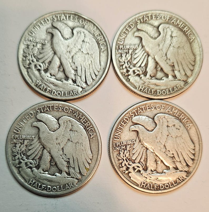 May include: Four silver United States half dollar coins with the image of a bald eagle on the front. The coins are from the 1900s and have the words "United States of America", "E Pluribus Unum", and "Half Dollar" inscribed on them.