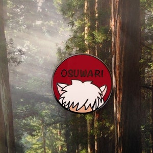Puede incluir: Un pin de esmalte rojo y blanco con la cabeza de un personaje de dibujos animados y el texto "OSUWARI" sobre un fondo rojo.