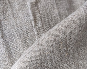 May include: Close-up of a natural linen fabric with a textured weave. The fabric is a light beige color and has a slightly rough feel.