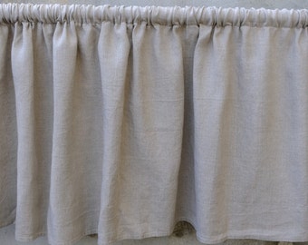 May include: A light gray linen valance with a gathered top and a ruffled bottom.