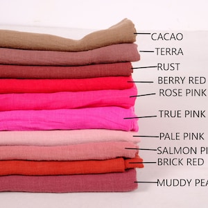 May include: A stack of ten fabric swatches in various shades of red and pink, labelled with names such as "Cacao", "Terra", "Rust", "Berry Red", "Rose Pink", "True Pink", "Pale Pink", "Salmon Pink", "Brick Red", and "Muddy Peach".