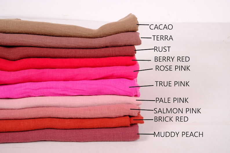 May include: A stack of ten fabric swatches in various shades of red and pink, labelled with names such as "Cacao", "Terra", "Rust", "Berry Red", "Rose Pink", "True Pink", "Pale Pink", "Salmon Pink", "Brick Red", and "Muddy Peach".