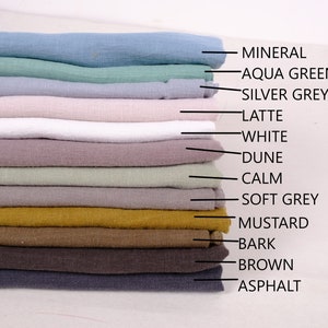 May include: A stack of 13 fabric swatches in various colours, including mineral, aqua green, silver grey, latte, white, dune, calm, soft grey, mustard, bark, brown, and asphalt.