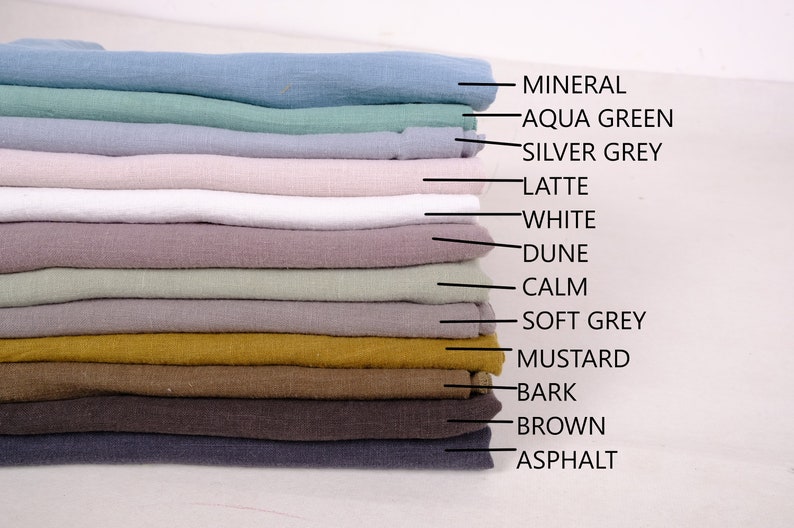 May include: A stack of 13 fabric swatches in various colours, including mineral, aqua green, silver grey, latte, white, dune, calm, soft grey, mustard, bark, brown, and asphalt.