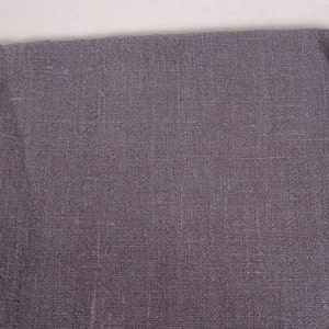 May include: A close-up of a piece of gray fabric with a textured weave. The fabric has a subtle sheen and a slightly rough feel.
