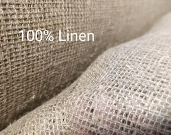 May include: Close-up of a natural brown woven fabric with a coarse texture. The fabric is labeled "100% Linen".