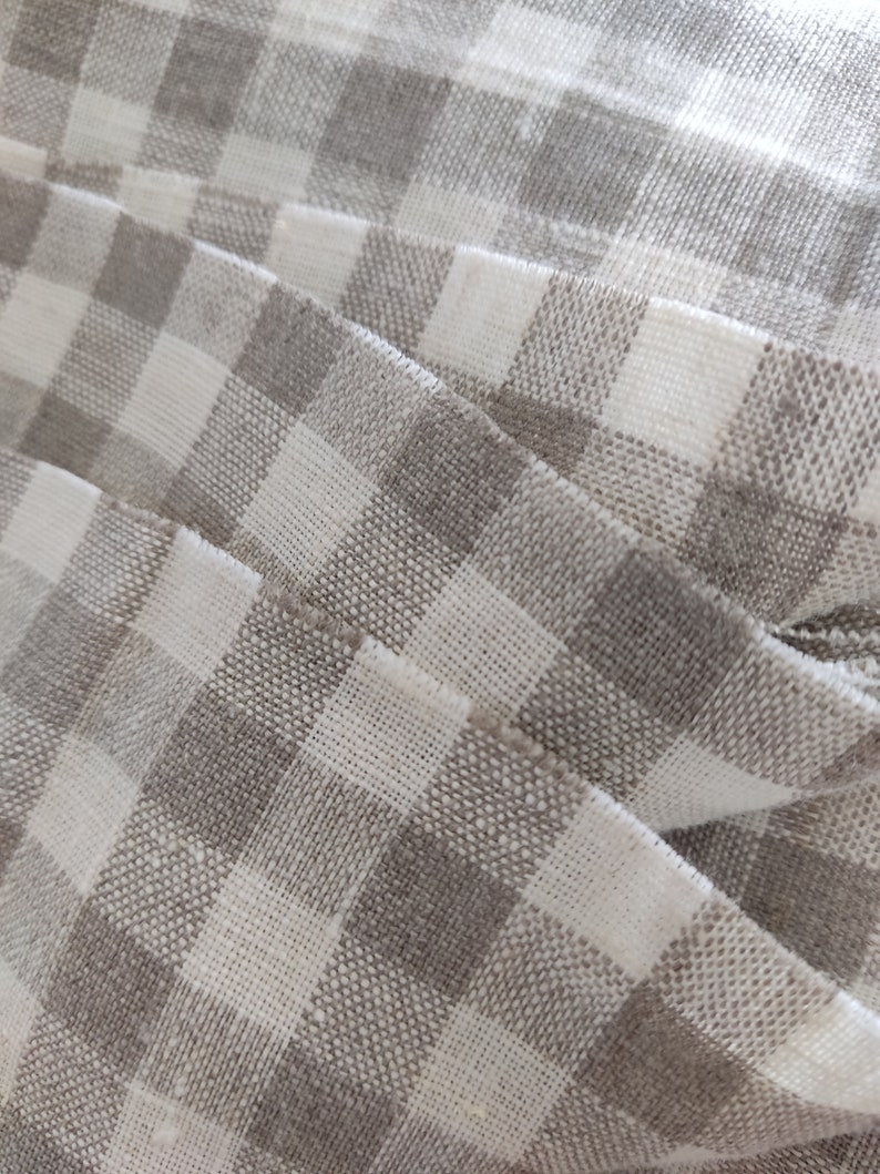 May include: Close-up of a white and gray checkered fabric with a woven texture.