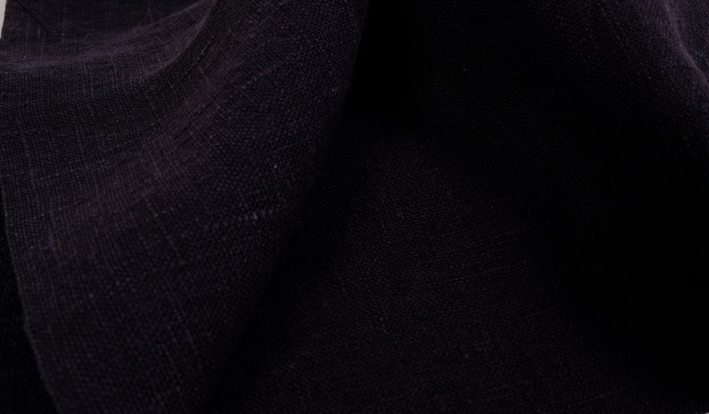 May include: Close-up of a dark blue fabric with a textured weave.
