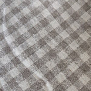 May include: A white and brown checkered fabric with a subtle woven texture.