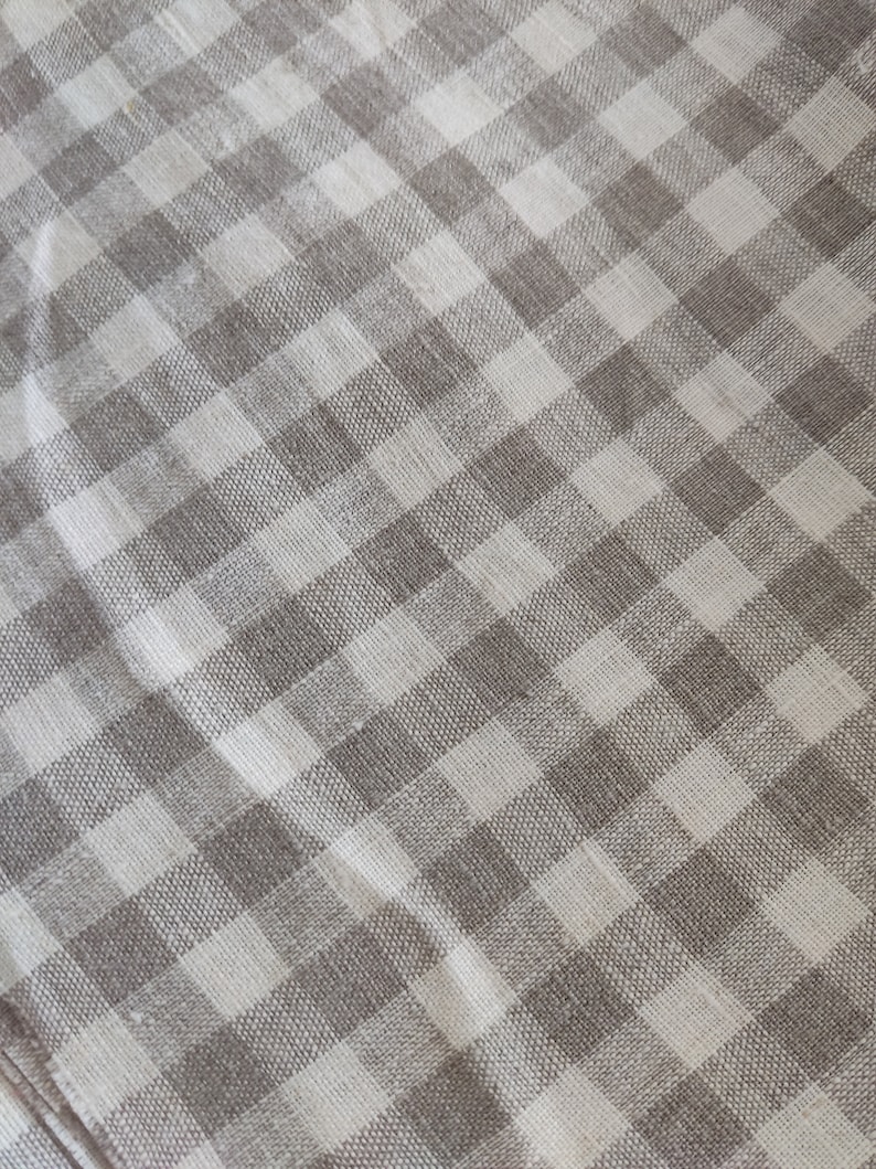 May include: A white and brown checkered fabric with a subtle woven texture.