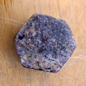 Peut inclure: Une pierre précieuse hexagonale brute, de couleur violette et grise, avec une finition naturelle non polie.