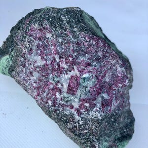 Peut inclure: Une tasse en céramique blanche avec une anse noire et le texte "But First, Coffee" en gras noir. La tasse est posée sur un fond flou. La tasse mesure environ 10 cm de hauteur.