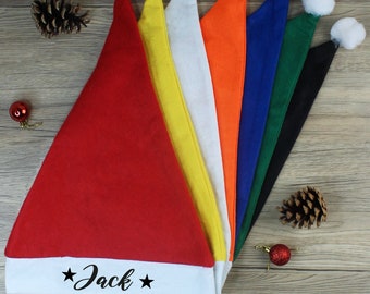 May include: A set of ten Santa hats in various colors, including red, white, yellow, orange, blue, green, and black. The hats have white pom-poms on top and a white band around the bottom with the name "Jack" written in black.