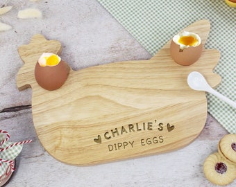 May include: Wooden chicken-shaped serving tray with two egg cups and a small spoon. The tray is engraved with "Charlie's Dippy Eggs" and two hearts.