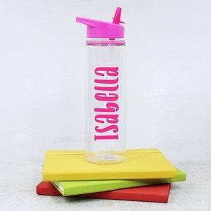 May include: A clear plastic water bottle with a pink lid and straw. The bottle has the name "Isabella" printed on it in pink.