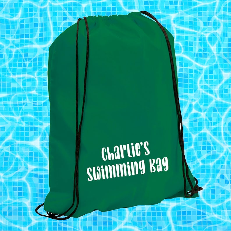 May include: A green drawstring bag with the text "Charlie's Swimming Bag" in white lettering.
