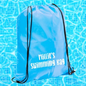 May include: A bright blue drawstring bag with black drawstrings. The bag has the text "Millie's Swimming Bag" printed in white.
