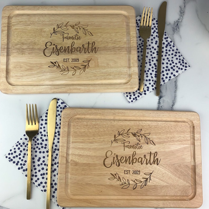 May include: Two wooden cutting boards with engraved text. The top board reads "Familie Eisenbarth EST. 2009" and the bottom board reads "Familie Eisenbarth EST. 2009".