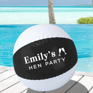 Puede incluir: Pelota de playa inflable blanca y negra con el texto "Emily's Hen Party" y dos copas de champán.