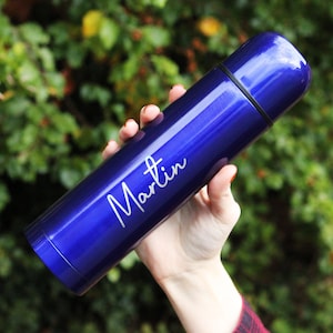 Op de afbeelding: Een blauwe waterfles van roestvrij staal met de naam "Martin" gegraveerd aan de zijkant.
